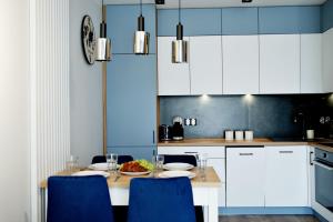 cocina con mesa y sillas azules en Apartment Bulwary 4, en Oświęcim