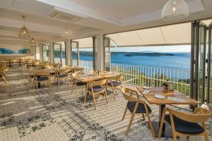 un restaurante con mesas y sillas y vistas al océano en Zlatni Zalaz,Apartments,Supetarska Draga en Supetarska Draga