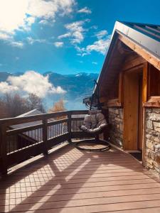 a bench on a deck with a view of the mountains at Cocon à la vue imprenable ! in La Plagne Tarentaise