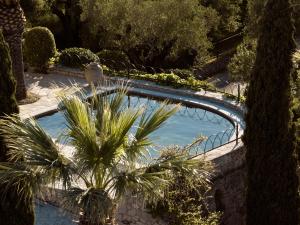 a swimming pool with palm trees and a bridge at Almeira 4acre Estate, for Unparalleled Seclusion, By ThinkVilla in Zakynthos Town