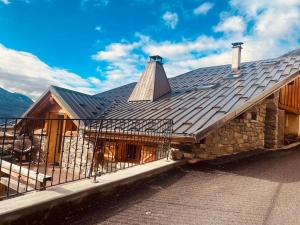 a house with a metal roof with a balcony at Cocon à la vue imprenable ! in La Plagne Tarentaise
