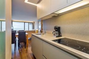 a kitchen with a counter and a dining room with a table at Rembrandt Glv in Wenduine