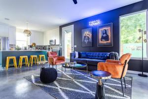 ein Wohnzimmer mit bunten Stühlen und einer blauen Wand in der Unterkunft Insa Worthy Two-Home Retreat - Fire Pit, Hot Tub in Austin