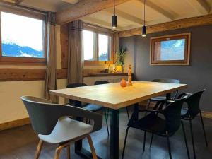 a dining room with a wooden table and chairs at Cocon à la vue imprenable ! in La Plagne Tarentaise