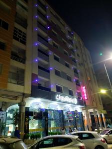 um edifício com carros estacionados em frente a ele à noite em FEKRI HOTEL em Meknès