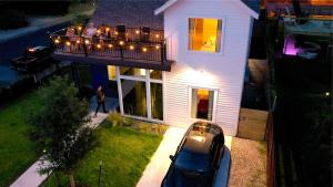 ein weißes Haus mit einem Balkon mit Lichtern darauf in der Unterkunft Insa Worthy Two-Home Retreat - Fire Pit, Hot Tub in Austin