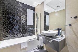 a bathroom with a sink and a toilet in it at Unlock Metropolis Business Bay in Dubai