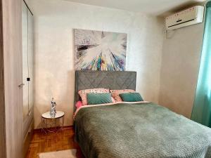 - une chambre avec un lit orné d'une peinture murale dans l'établissement Belgrade Apartment 1, à Zvezdara