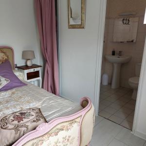 1 dormitorio con 1 cama y baño con lavamanos en Cap'tain Cook en Caurel