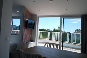 a room with a table and a balcony with a television at Apartamentos Sunway Atlanta in Sitges