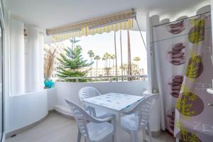 a dining room with a table and chairs and a window at Paraiso maspalomas sunset in San Bartolomé de Tirajana