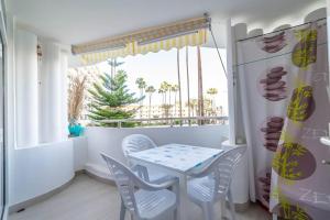 a dining room with a table and chairs and a window at Paraiso maspalomas sunset by CALIMA HOMES in San Bartolomé