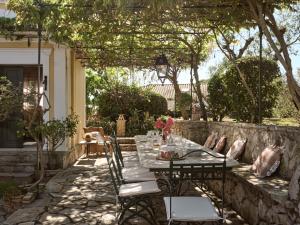 un patio con mesa y sillas bajo una pérgola en Almeira 4acre Estate, for Unparalleled Seclusion, By ThinkVilla en Zakynthos