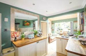 a kitchen with green walls and a counter top at Marwood Cottage in Ripon