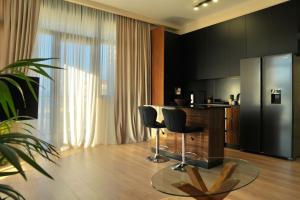 トビリシにあるLuxury VIP apartmentのテーブルと椅子2脚、冷蔵庫付きのキッチン