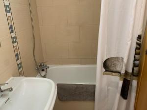 a bathroom with a sink and a toilet and a tub at Luminoso ático en centro ciudad - Alquiler de temporada in Puerto de Sagunto