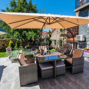 a patio with a table and chairs under a large umbrella at Villa MAJESTIC in Mali Lošinj