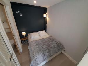 a small bed in a room with a black wall at Studios Village Naturiste Port Venus Enigma & Studio Port Soleil Orchidée in Cap d'Agde