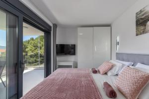 a bedroom with a bed and a sliding glass door at Apartment Island Krk Queen 1 in Krk +31 photos