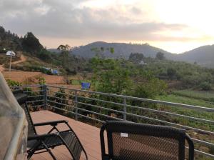 balcón con 2 sillas y vistas al valle en L.T NATURE GLAMPS, en Kodaikanal
