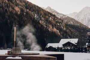 a building in front of a snow covered mountain at Aethos Monterosa in Champoluc