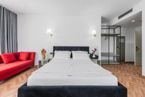 a bedroom with a large bed and a red couch at Polifonia City Loft - Hotel rooms Vlorë, Albania in Vlorë