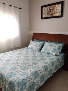 Pousada La Casona في تيباجي: غرفة نوم مع سرير مع لحاف و نافذة