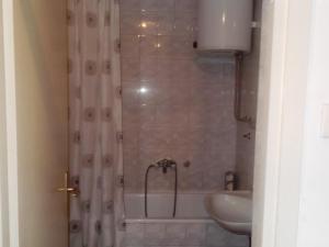 a bathroom with a shower with a tub and a sink at Bubin apartman in Novi Beograd