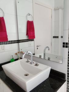 uma casa de banho com um lavatório branco e um espelho. em Pousada La Casona em Tibagi