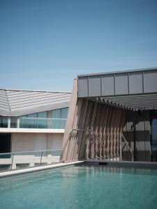 een gebouw met een zwembad ervoor bij Boutique Hotel Blendin Bloemendaal aan Zee in Overveen