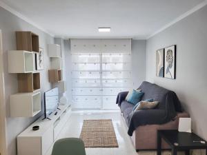 un soggiorno con un divano e una TV di Cristimar Roja Beach a Los Cristianos