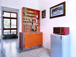 La cuisine est équipée d'un réfrigérateur et d'un four micro-ondes rouge. dans l'établissement 朗香洋房 法式老洋房 台南民宿684編號, à Anping