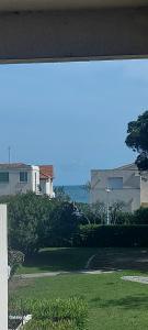 uma vista para uma casa com o oceano ao fundo em Studio vue port à 50m plage em Carnon-Plage