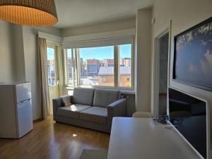 uma sala de estar com um sofá e uma televisão de ecrã plano em Borent Suite Apartment em Turku