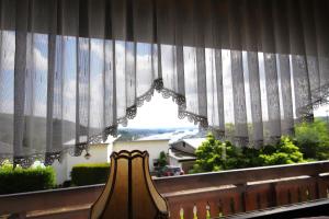 ein Fenster mit Vorhängen mit Blick auf ein Haus in der Unterkunft Ferienwohnung Rheinblick in Bingen am Rhein