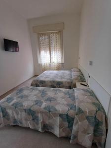 1 Schlafzimmer mit 2 Betten und einem Fenster in der Unterkunft Hotel Flora in Cesenatico