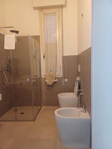 y baño con ducha, bañera y lavamanos. en Hotel Flora, en Cesenatico