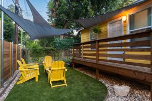 un patio con sillas amarillas y una casa en Amazing Backyard in Lively Area - BBQ & Firepit en Austin