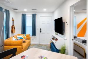 ein Wohnzimmer mit einem Sofa und einem TV in der Unterkunft Amazing Backyard in Lively Area - BBQ & Firepit in Austin