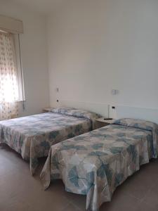 2 Betten nebeneinander in einem Zimmer in der Unterkunft Hotel Flora in Cesenatico