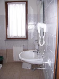 a bathroom with a sink and a phone on the wall at Villa Giovanna in Somma Lombardo