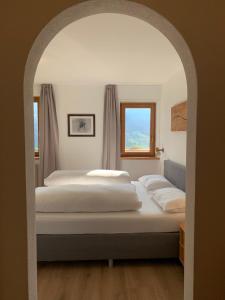 1 dormitorio con 2 camas y ventana en Apartments Stroblhof, en Ortisei