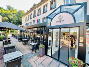 un restaurant avec des tables et des chaises en face d'un bâtiment dans l'établissement Koener Hotel & Spa, à Clervaux