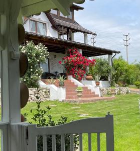 una casa con una cerca blanca y algunas flores en Conacul Paloși, en Horezu