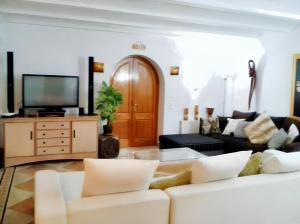 a living room with a couch and a tv at 5 bedrooms villa at Sant Josep de sa Talaia 900 m away from the beach with sea view private pool and enclosed garden in Sant Josep de Sa Talaia