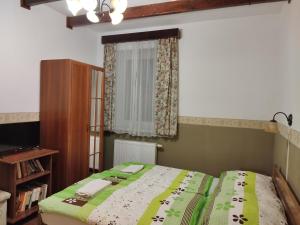 1 dormitorio con 1 cama con edredón verde en Ódon Panzió en Bükkszentkereszt