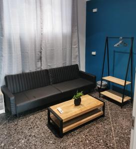 Central Hostel في أثينا: غرفة معيشة مع أريكة سوداء وطاولة