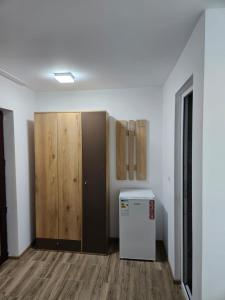 an empty room with a refrigerator and wooden cabinets at Ionela in Eforie Nord +5 photos