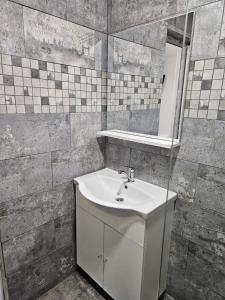 a bathroom with a white sink and a mirror at Ionela in Eforie Nord