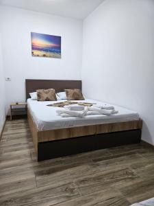 a bedroom with a large bed with white sheets at Ionela in Eforie Nord